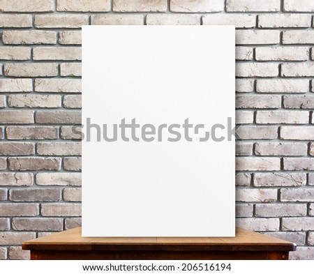 blank poster on wood table at brick wall,perspective background