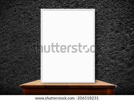 blank photo frame on wood table at black stone wall,perspective background