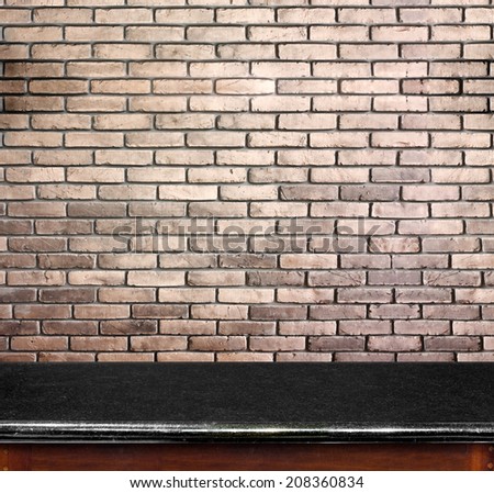 Empty black marble table and brick wall in background. product display template.