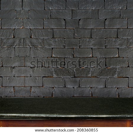 Empty black marble table and black brick wall in background. product display template.