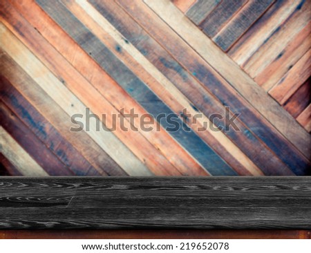 Black wood table at blurred colorful plank wooden wall in background,Template for display your product