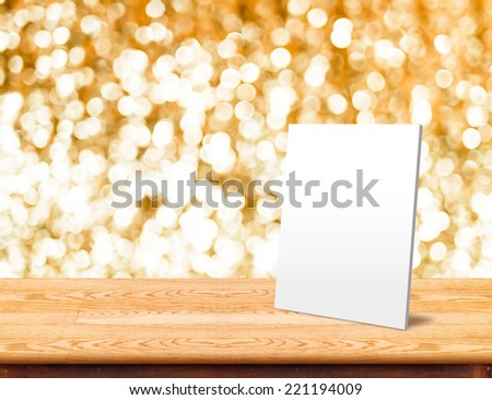 White paper frame at Wood Table with bokeh golden sparkling background,Empty room for display your product