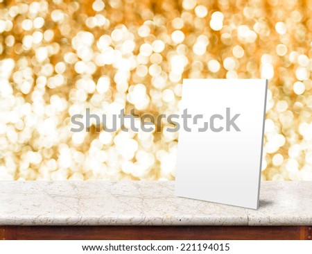 White paper frame at marble Table with bokeh golden sparkling background,Empty room for display your product