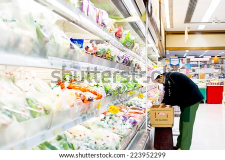 Bangkok ,Thailand-August 30 : Woman officer puts in order of Fresh vegetable into product shelf on 30 August 2014 at Foodland supermarket store, Bangkok, Thailand.