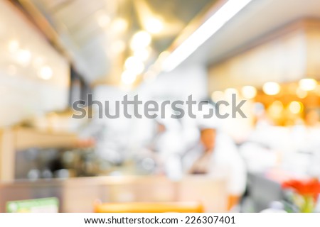 Blurred background : Groups of Chef cooking in the open kitchen,customer can see they cooking at food counter, cooking chef with light bokeh
