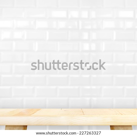 Empty light wood table and blur white ceramic tile brick wall in background,Mock up template for display of your product