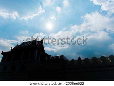 silhouette photo of Thai fortress with sun beam over rooftop with sky and cloud
