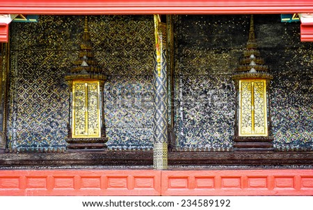 Thai style art painting wall and golden windows Thai temple bangkok Thailand