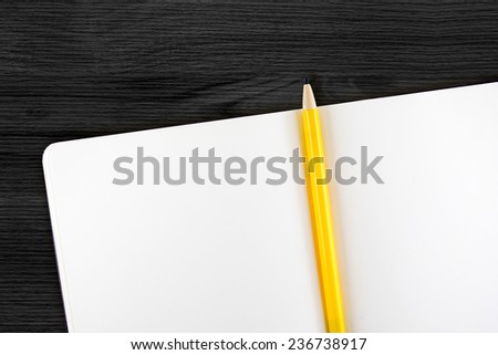 Open blank notebook with yellow pencil on black wooden table,Template mock up for adding your content