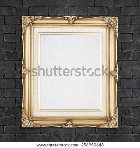 Blank Gold color vintage photo frame hanging on black brick wall