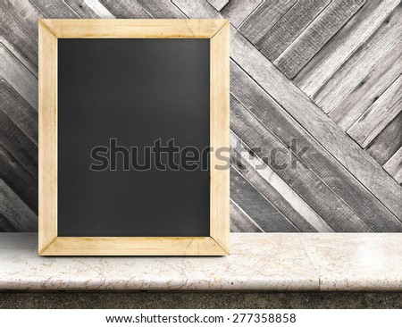Blank blackboard on marble table at diagonal wooden wall,Template mock up for adding your design and leave space beside frame for adding more text