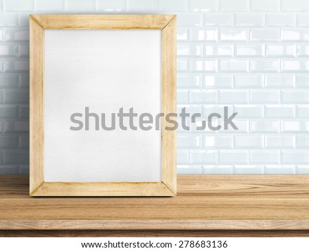 Blank whiteboard wood frame on wooden table at white tile wall,Template mock up for adding your design and leave space beside frame for adding more text.
