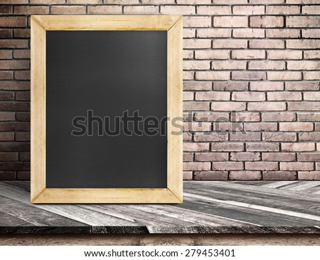 Blank blackboard on diagonal wooden table at red brick wall,Template mock up for adding your design and text.