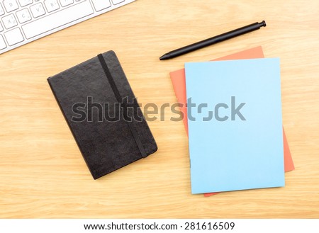 Blank Black,blue and orange notebook ,pen and keyboard on wooden table , Mock up for adding your design