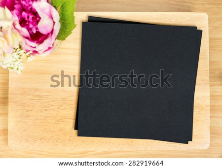 Top view of Blank wooden plate with black paper and flower pot on table top,Mock up for adding your design, Clipping path on paper card.