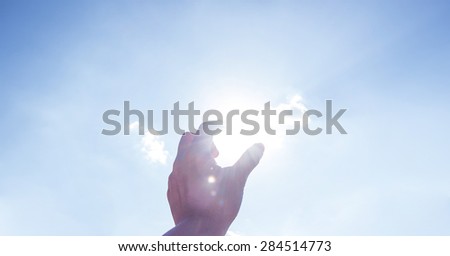 Hand picking sun at blue sky and cloud