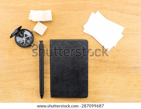 Black notebook, pen,compass and business card on wood table,Mock up for adding your design