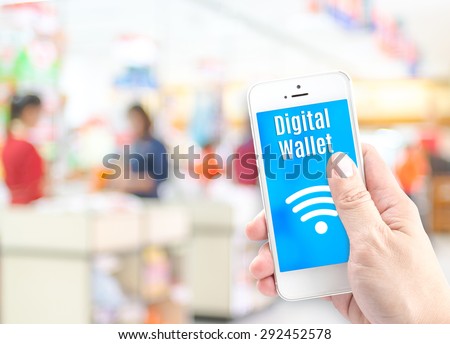 Hand holding mobile phone with digital wallet at supermarket blur background, Digital economy concept.