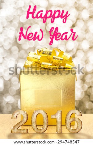 Golden Present box on wood table with Happy New Year 2016 word at bokeh light background, Holiday concept