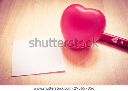 Vintage filter,Notepad with heart toy and red pen on wooden table,Template mock up for adding your content, love concept