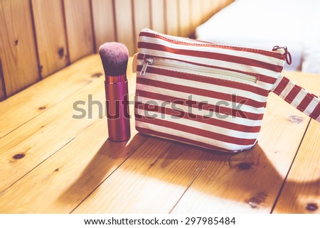 vintage filter, cosmetic bag on wooden table.