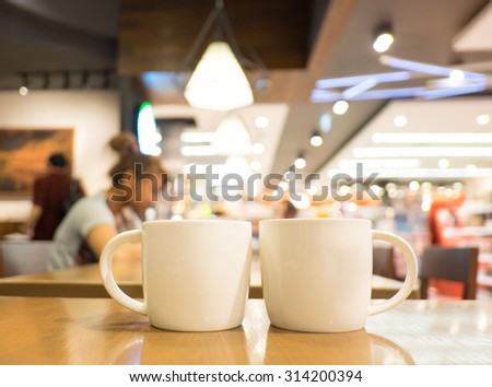 Coffee cup on wood table in cafe with blur background, Leisure lifestyle concept.