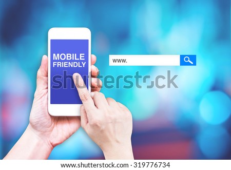 Hand touch mobile phone with  mobile friendly word with search box at blurred blue background, Digital marketing business concept
