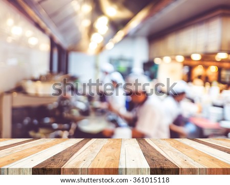 Empty wood table with blur open cooking restaurant background,Mock up Template for montage of your product