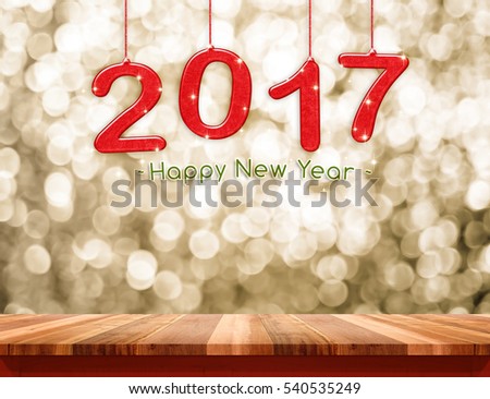 2017 happy new year hanging over plank wood table top with gold sparkling bokeh wall,Holiday concept,leave space for adding your content