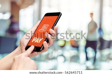 Hand holding mobile with pay word and bill icon feature with blur back office counter background,Digital Lifestyle concept