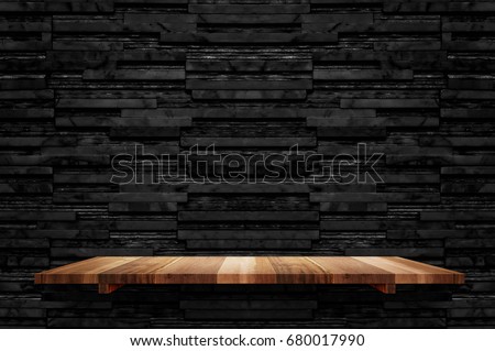 Empty brown plank wood shelf at black layer marble tile wall background,Mock up for display or montage of product or design