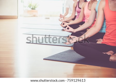 Close up hands of yoga group seated doing Hand Mudra and meditates in a training studio fitness room, Calm and relax concept,wellness and healthy lifestyle,leave space for adding text