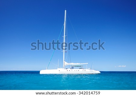 Beautiful cloudscape and sailing catamaran in the blue carribean sea