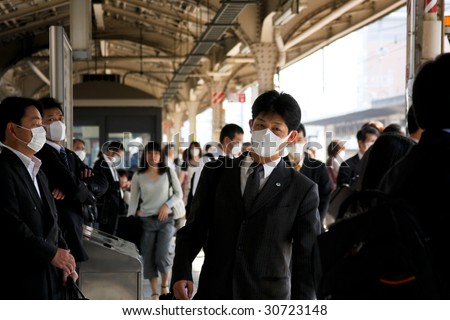 KOBE, JAPAN - MAY 20: People on the street wear face masks because of the outbreak of swine flu, Sannomiya JR station on May 20, 2009 in Kobe, Japan.