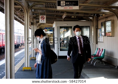 KOBE, JAPAN - MAY 20: People on the street wear face masks because of the outbreak of swine flu near Sannomiya JR station May 20, 2009 Kobe
