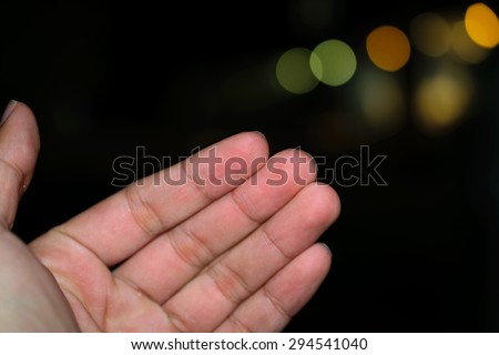 Hand reaching up in the candle lights bokeh : Isolated male empty open hand raised upward