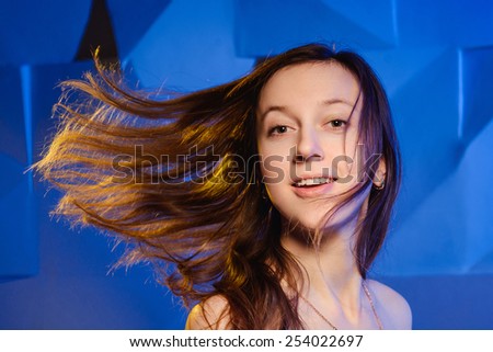 Portrait of beautiful young woman with fluttering hair