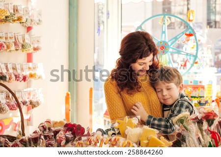 Son tenderly embracing his mother in the sweets store
