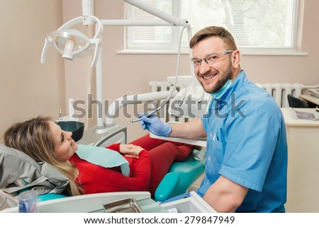 Portrait of smiling male dentist and woman patient in a dentist office