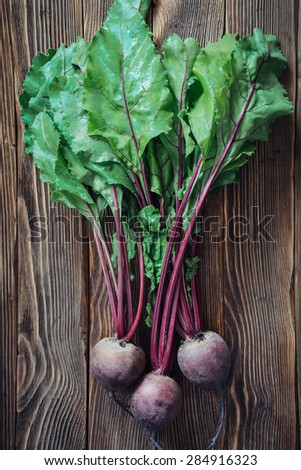 Close up of fresh beetroot leaves on rustic wooden background, top view
