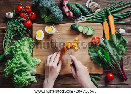 Healthy food and ingredients with tomato, salad, arugula, carrots, beetroot, leaves, cucumber, onion, radish, mushrooms, garlic, broccoli, half, egg and peas on rustic wooden background, top view