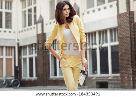 Smart brunette woman clothed yellow suit