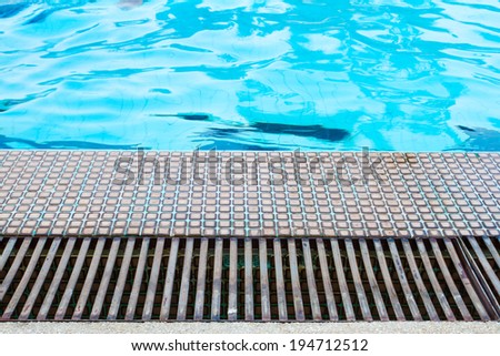 Swimming pool side with drain