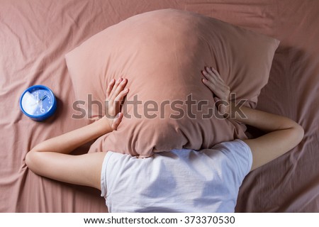 woman cover her head with pillow, sleeping problem concept
