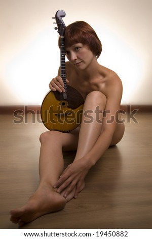 stock photo Beautiful naked model with russian folk instrument domra