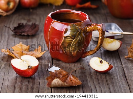 Apple tea in apple cup and  apples over rustic wooden background