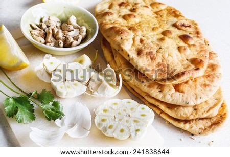 Pile of freshly baked flat bread and garlic on a table