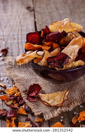 Healthy vegetable beetroot, sweet potato and white sweet potato chips on a bowl on a rustic background. Selective focus