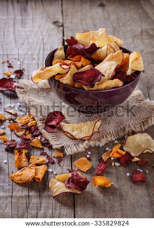 Healthy vegetable beetroot, sweet potato and white sweet potato chips on over rustic background