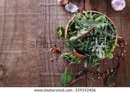 Leafy green mix of kale, spinach, baby beetroot leaves over rustic wooden background. Copy space, selective focus
